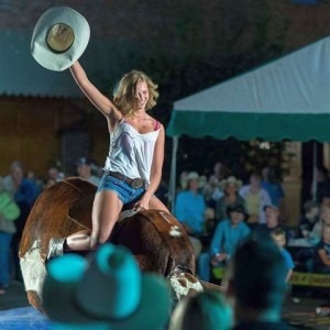 mechanical bull girl waving hat